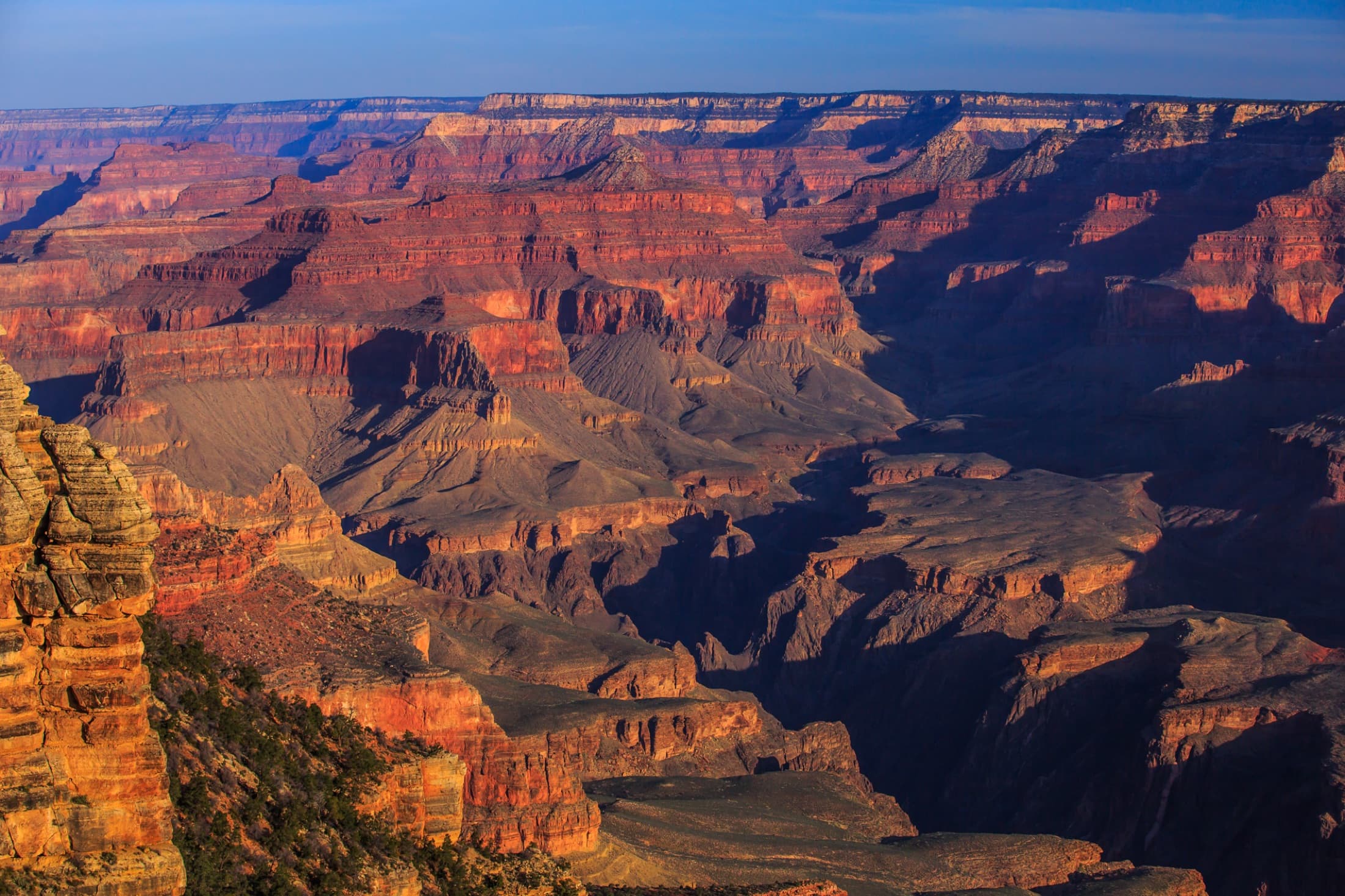 Dawn light over the layered red and orange cliffs and buttes of the Grand Canyon, seen from the South Rim of Grand Canyon National Park, Arizona