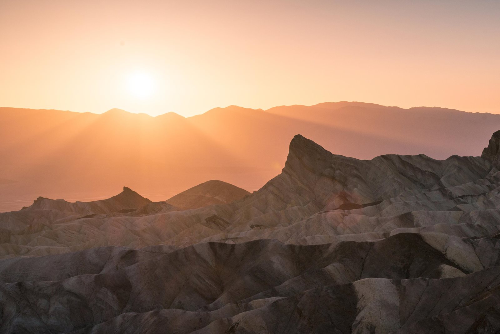 Zabriskie Point badlands glowing pink and orange at sunset