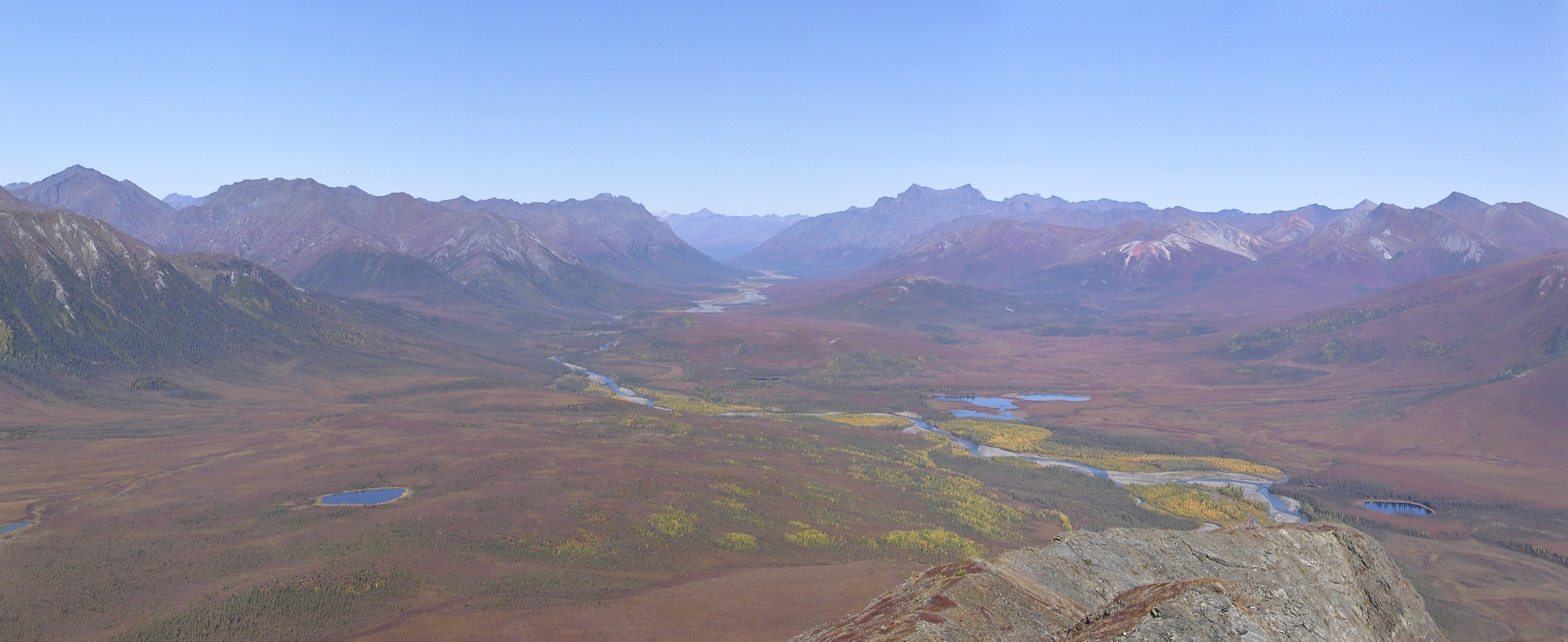 The North Fork of the Koyukuk River winding through the Brooks Range between the steep peaks of Frigid Crags and Boreal Mountain, the namesake "gates" of Gates of the Arctic National Park and Preserve, Alaska, seen from the summit of Eroded Mountain.