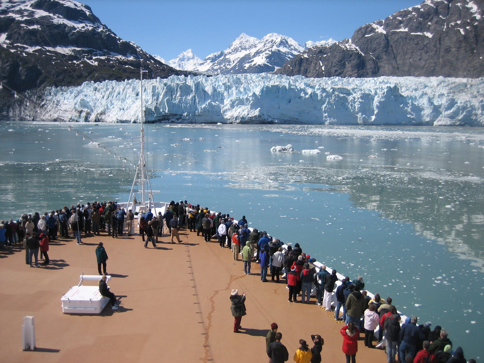 A tour boat cruising through Glacier Bay below steep mountains