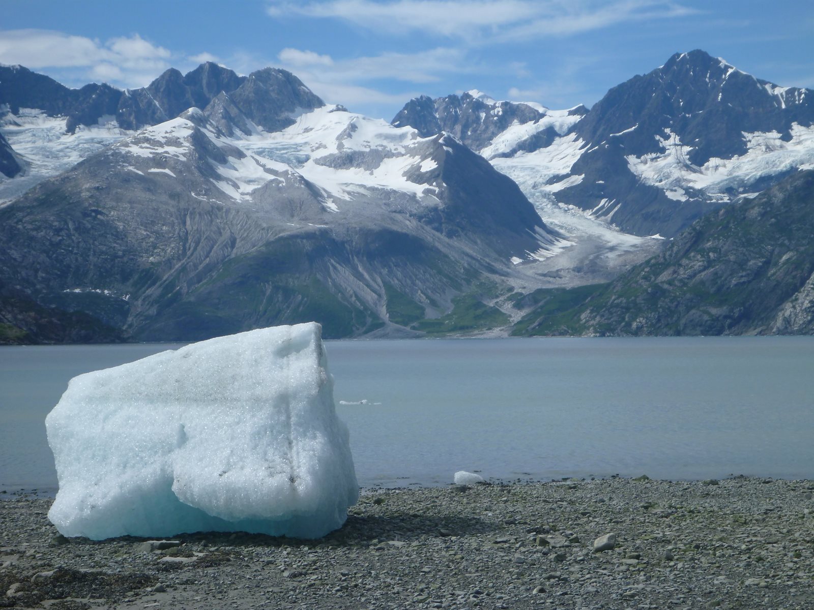 A blue iceberg resting along the rocky shore of Glacier Bay