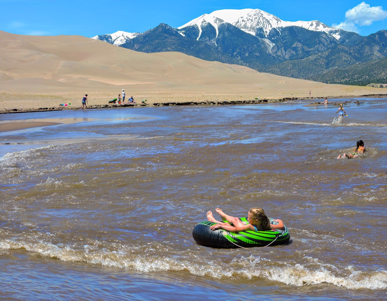 A child playing in Medano Creek below the dunes
