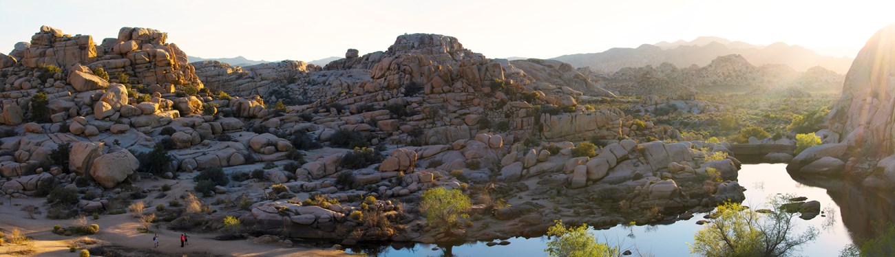 Barker Dam with desert rock walls and reflected sky