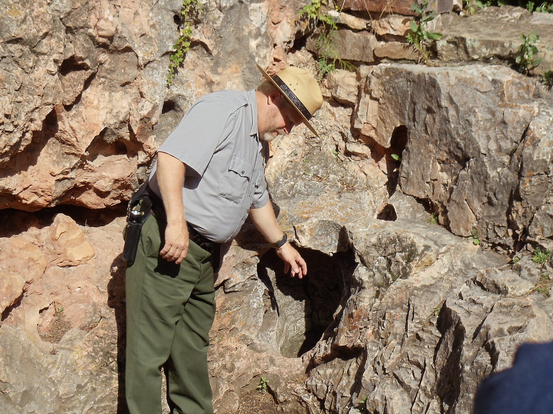 The small natural entrance to Wind Cave set into rock